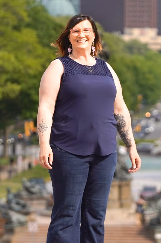 Woman in an outdoor scene with tattoos on her arms.